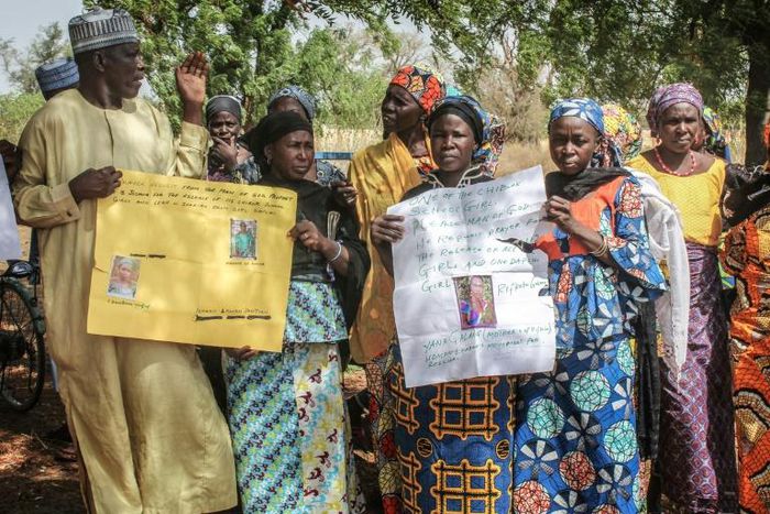 Parents and relatives hold pictures of girls missing since they were abducted by Boko Haram on April 14, 2014 in Chibok, northern Nigeria