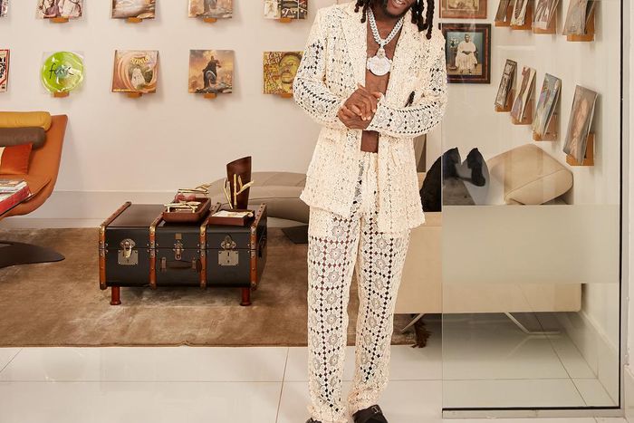 Burna Boy poses against the backdrop of old records for Architectural Digest