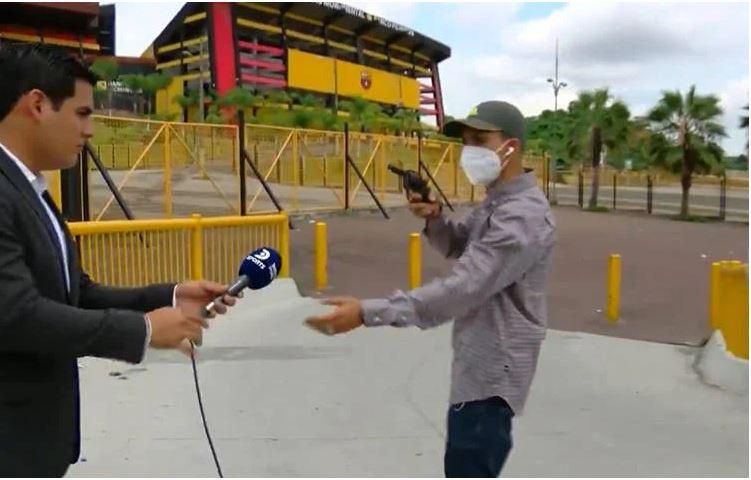 Mask-wearing robber robs journalist at gunpoint during live report