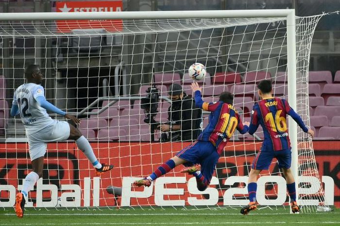 Great leveller: Lionel Messi heads in against Valencia to equal Pele's record for goals scored for one club