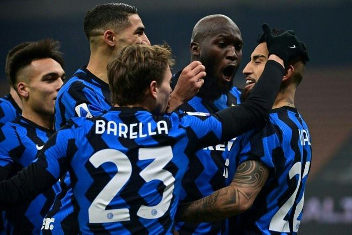 Inter Milan midfielder Arturo Vidal (R) and Nicolo Barella (C) celebrate after scoring against Juventus.