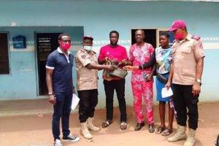 Second from left, the  FRSC Unit Commander in Oraifite, Mr Bamidele Ayanwale,  presenting the cash to the  family of the deceased on Tuesday. [NAN]