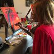 A lady painting at a sip and paint event [Instagram/sipandpaintng]