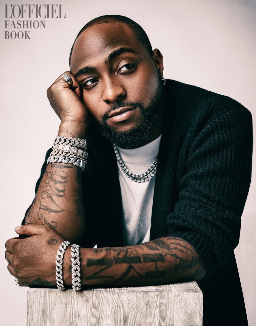 Davido on L'Officiel Magazine the Cardigan is from Dries Van Noten, T-shirt by Salvatore Ferragamo, Trousers by Ungaro, Shoes by Giuseppe Zanotti, Jewelry is Davido’s own [L'Officiel]