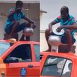 Ghanaian man cooks with coalpot on top of moving taxi while sitting on kitchen stool (video)