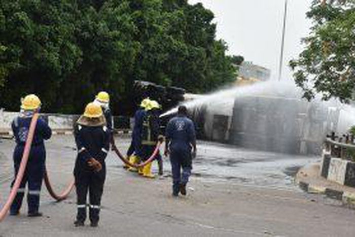 Firemen spraying water to avert fire at the scene of a tanker loaded with cooking gas that fell on Constitution Avenue at Centre Business District in Abuja on Wednesday. [NAN]