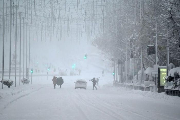 Snow stopping: People walk amid a heavy snowfall in Madrid