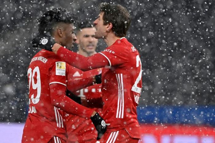 Kingsley Coman (L) celebrates with Thomas Mueller after putting Bayern Munich in front against Hertha Berlin in the snow in the German capital