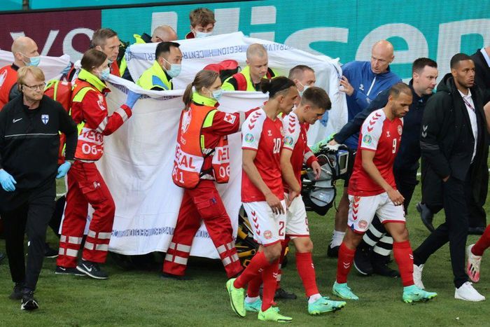 Players escort paramedics as Denmark's midfielder Christian Eriksen is evacuated from the pitch during the UEFA EURO 2020 Group B football match between Denmark and Finland at the Parken Stadium in Copenhagen on June 12, 2021.