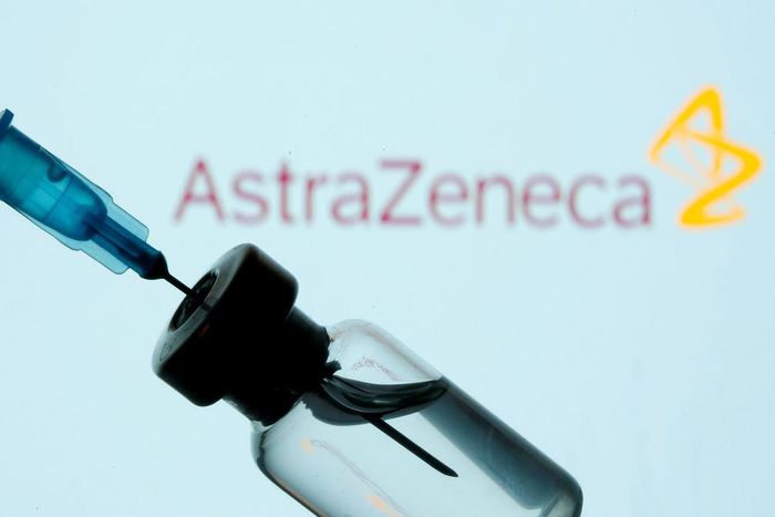 A vial and syringe in front of an AstraZeneca logo, January 11, 2021.