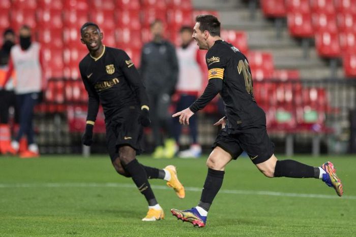 Lionel Messi celebrates with Ousmane Dembele after scoring one of his two goals in Barcelona's 4-0 win at Granada