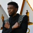 Actor Chadwick Boseman -- who plays the title role in "Black Panther" -- makes the Wakanda Forever arm gesture on the Oscars red carpet in March 2018
