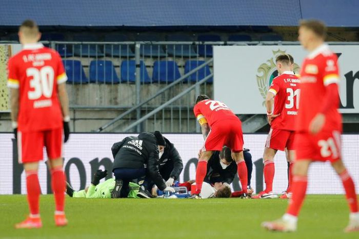 Worrying moment: Union Berlin goalkeeper Andreas Luthe and defender Julian Ryerson receive medical attention