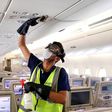 A member of the cleaning staff disinfects air vents aboard an Emirates plane; the company Medistar says its new air filtration system based on heated nickel foam can be placed inside air conditioning systems or walked through a plane via a mobile unit