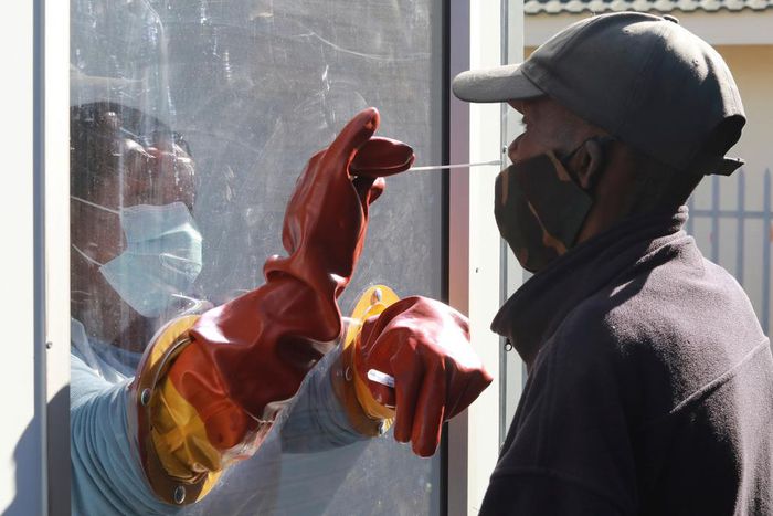Health worker Vuyiseka Mathambo takes a nasal swab from a patient to test for COVID-19 at a Masiphumelele community center in Cape Town, South Africa on July 23, 2020.