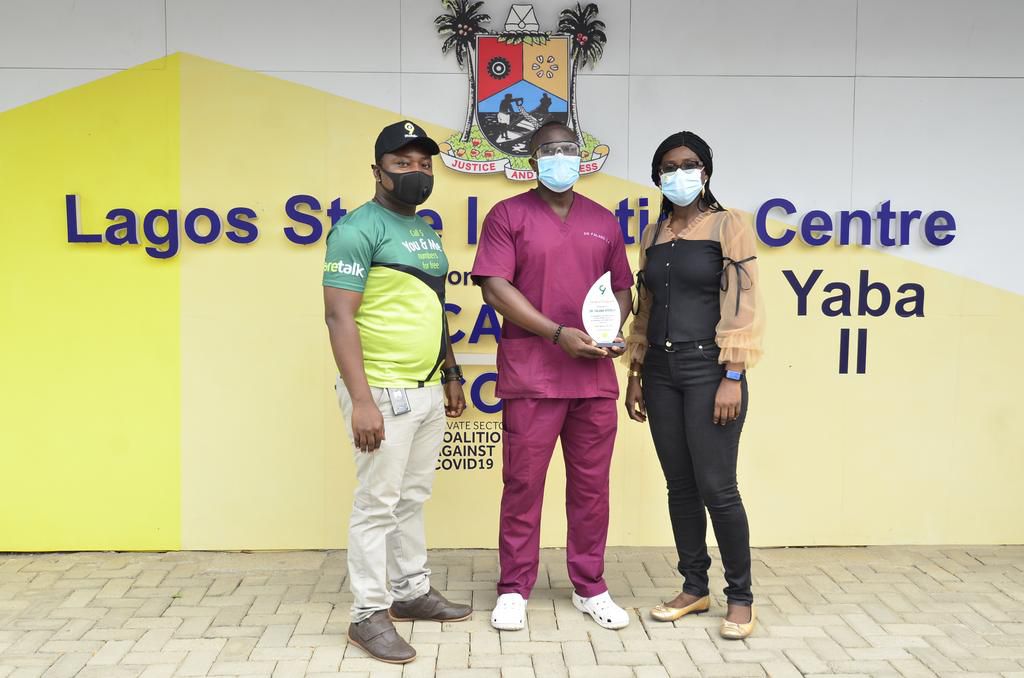 (L-R) Joshua Oluranti, Public Relations and CSR Specialist, 9mobile; Dr. Ayodeji Anthony Falana receiving an award as most outstanding health worker in the fight against COVID-19 and Chineze Amanfo, Corporate Communications Lead, 9mobile during an even...