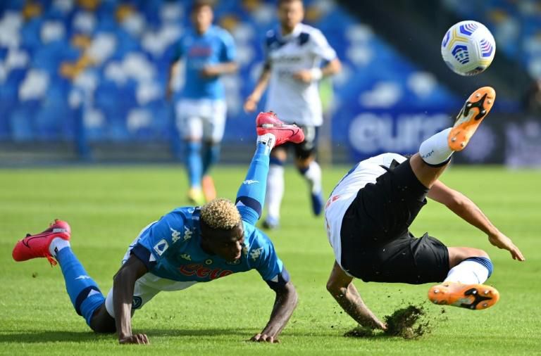 Nigerian Victor Osimhen (L) of Napoli falls as Cristian Romero clears for Atalanta