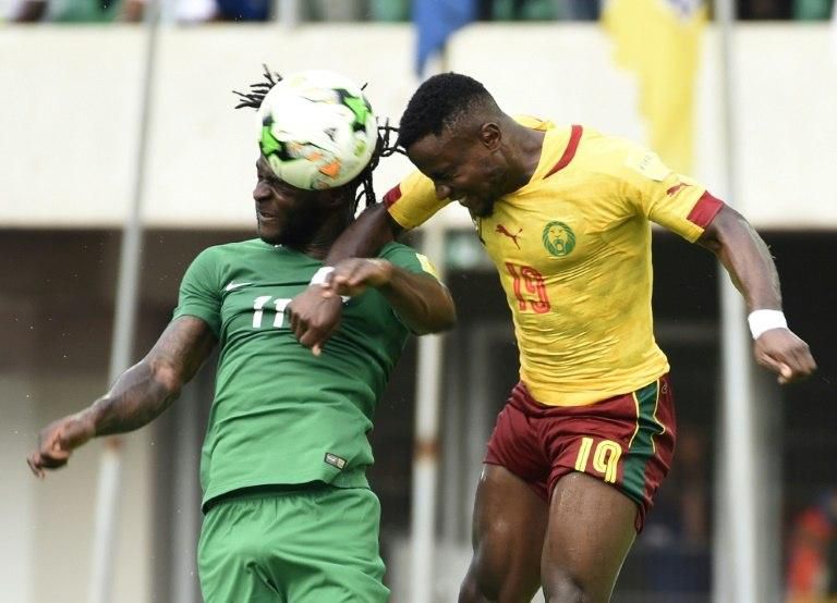 Nigeria's Victor Moses (L) heads the ball with Cameroon's Ngoran Fai during their match at Godswill Akpabio International Stadium in Uyo, southern Nigeria, on September 1
