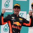 Red Bull's Dutch driver Max Verstappen (L) celebrates on the podium after winning the Formula One Malaysia Grand Prix next to second-placed Mercedes' British driver Lewis Hamilton, in Sepang, on October 1, 2017