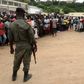 Security officials stand guard as people wait for friends and relatives fleeing an attack claimed by ISIS-linked insurgents on Palma in Mozambique, April 1, 2021.