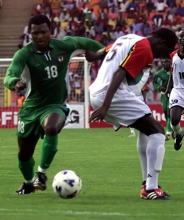 Nigeria's Yakubu Ayegbeni (L) dribbles behind Ghana's Antwi Williams (R) at the Abuja Stadium on May 30, 2003, during the four nations LG Cup