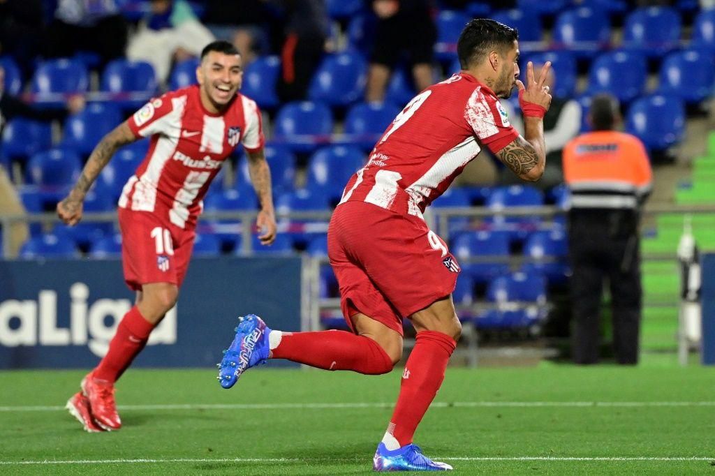 Angel Correa (left) and Luis Suarez (right) celebrate Atletico Madrid's late goal against Getafe on Tuesday.