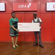 L-R : Group Head, Retail Products & Sales, United Bank for Africa, Ogechi Altraide; presenting N100,000 Cash prize to one of the Bumper Savings account draw winner,  Kenneth Ebietomere, during the draw held at the UBA House, Marina….. on Friday