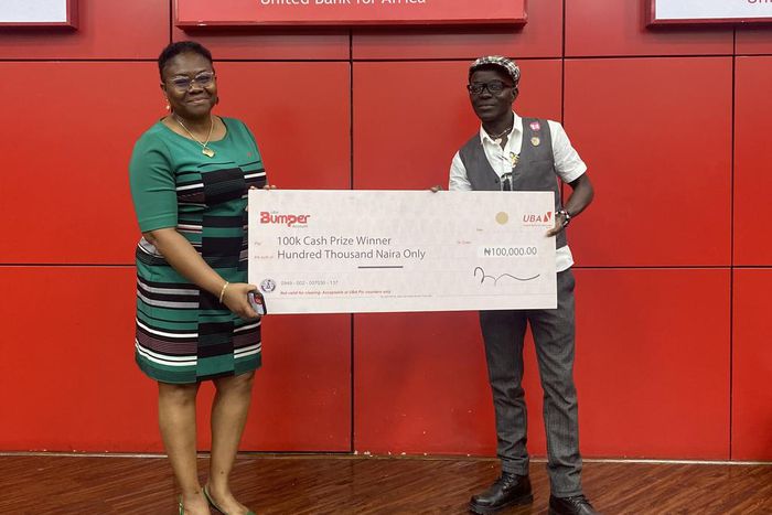 L-R : Group Head, Retail Products & Sales, United Bank for Africa, Ogechi Altraide; presenting N100,000 Cash prize to one of the Bumper Savings account draw winner,  Kenneth Ebietomere, during the draw held at the UBA House, Marina….. on Friday