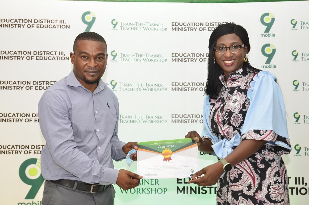 L-R- Ayejuyo Segun receiving the certificate of participation from PR Lead, 9mobile, Chineze Amanfo, during 9mobile Train-The-Trainer workshop for teachers in Education District III Lagos.