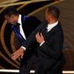 Will Smith, right, hits presenter Chris Rock on stage while presenting the award for best documentary feature at the Oscars on Sunday, March 27, 2022, at the Dolby Theatre in Los Angeles.