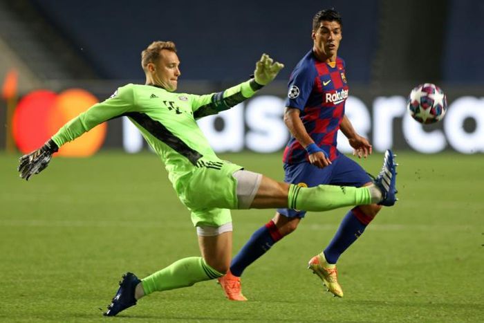Bayern Munich goalkeeper Manuel Neuer (L) clears the ball against Barcelona.