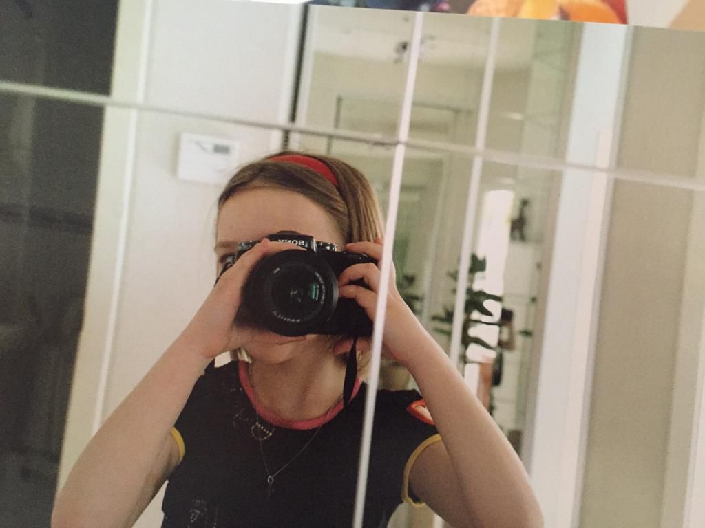 Finley Muratova, pictured here at age 10 taking a selfie with their father's camera.