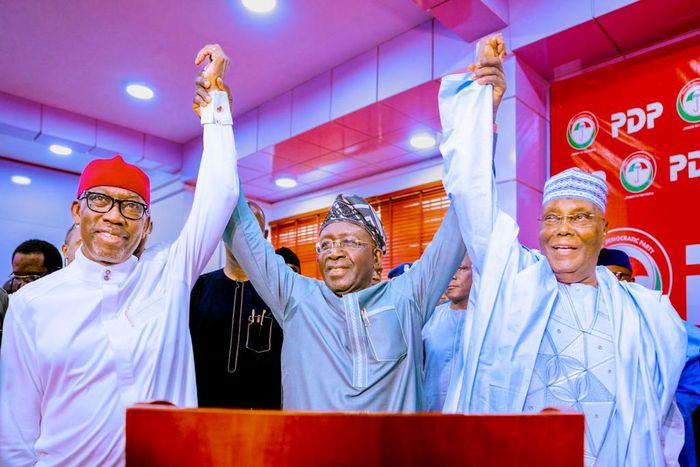 PDP National Chairman, Iyorchia Ayu (middle) raises the hands of former Vice President, Atiku Abubakar (right) and Governor Ifeanyi Okowa (left) as President and Vice Presidential candidates of the party. (Delta State Govt)