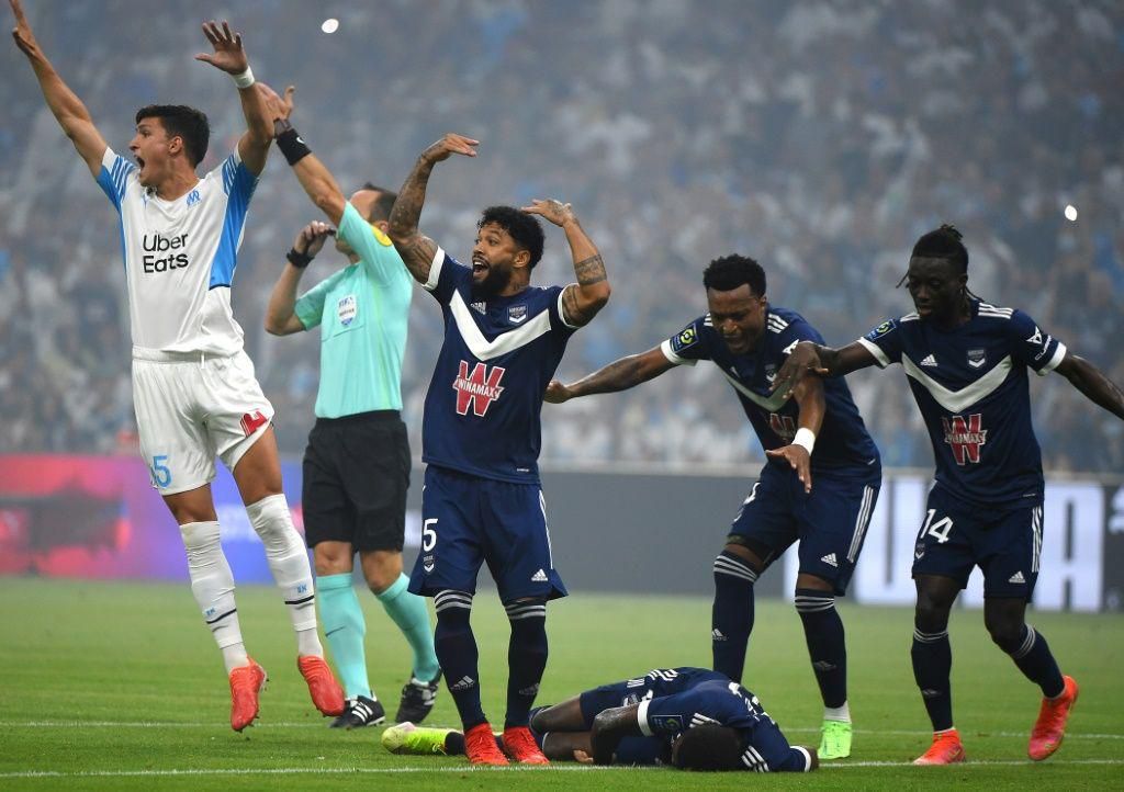 Bordeaux and Marseille's players call for medical help as Samuel Kalu lies on the ground