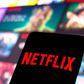 The Netflix logo is displayed on a smartphone screen.