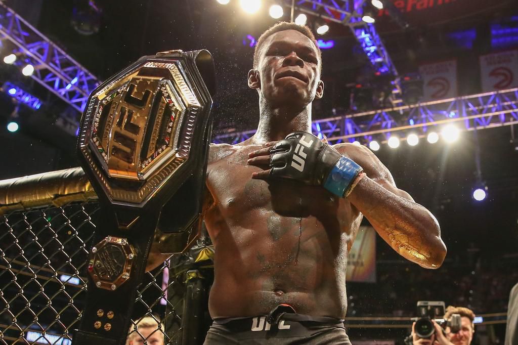 UFC Middleweight Champion Israel Adesanya hoists his belt.