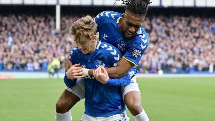 Alex Iwobi celebrates with goalscorer Anthony Gordon.