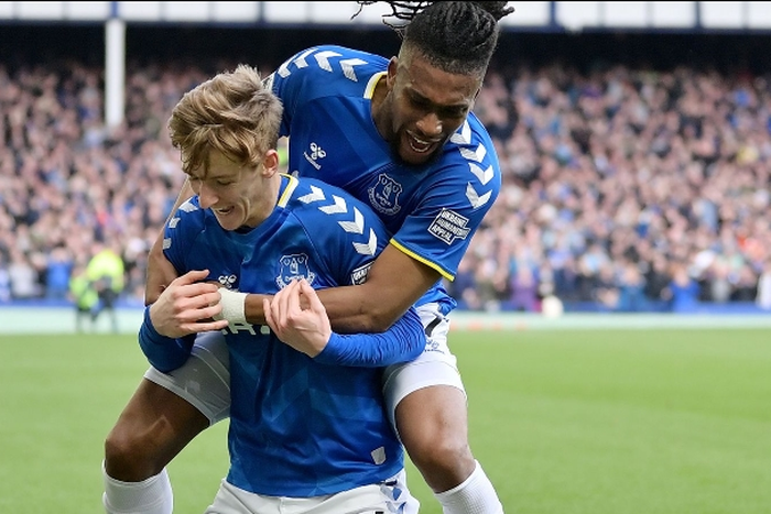 Alex Iwobi celebrates with goalscorer Anthony Gordon.