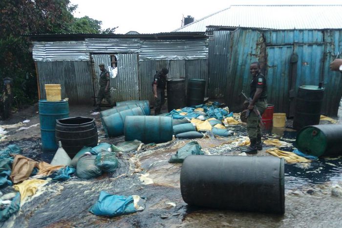 Police officers destroying illegally refined diesel in Warri [NAN]