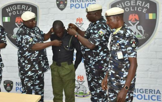 Police officer, Richard Gele, being stripped of Police uniform. [Daily Trust]