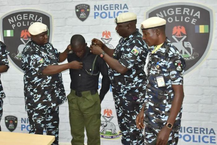 Police officer, Richard Gele, being stripped of Police uniform. [Daily Trust]