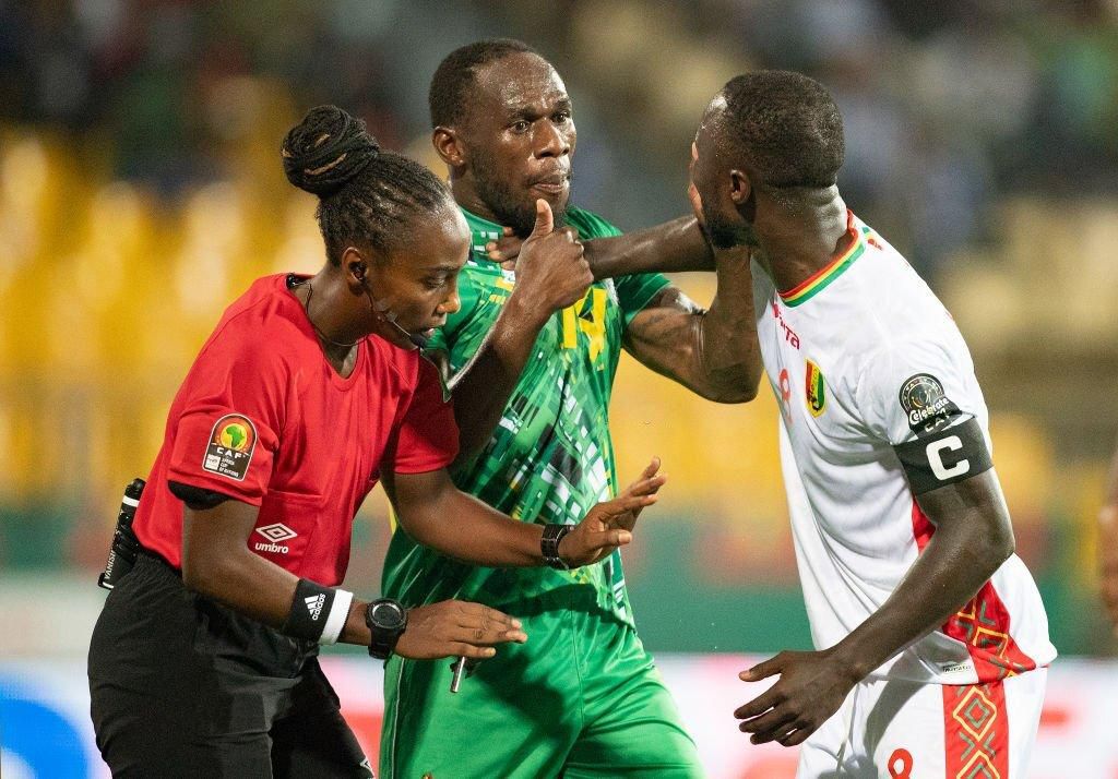 Salima Mukansanga of Rwanda in action as she becomes the first woman to referee a match at the finals of the Africa Cup of Nations as she keeps control between ONISMOR BHASERA of Zimbabwe and NABY KEÏTA of Guinea during the Group B Africa Cup of Nation...