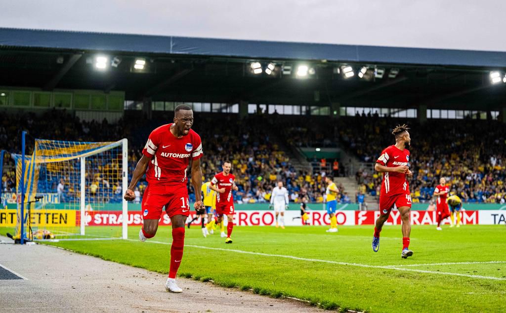 Chidera Ejuke (r) joins goalscorer Dodi Lukebakio (l) in celebrating Hertha Berlin's fourth goal in the 106th minute