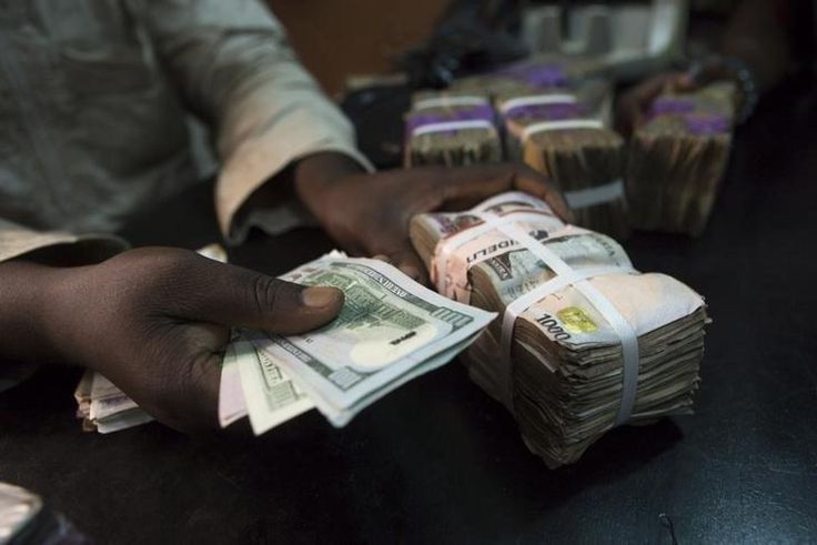 A trader changes dollars with naira at a currency exchange store in Lagos February 12, 2015. REUTERS/Joe Penney