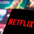 The Netflix logo is displayed on a smartphone screen.