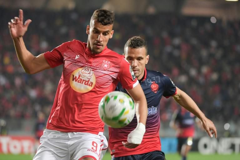 Karim Aribi (L) of Etoile Sahel shields the ball from Abdellatif Noussir of Wydad Casablanca in Tunis