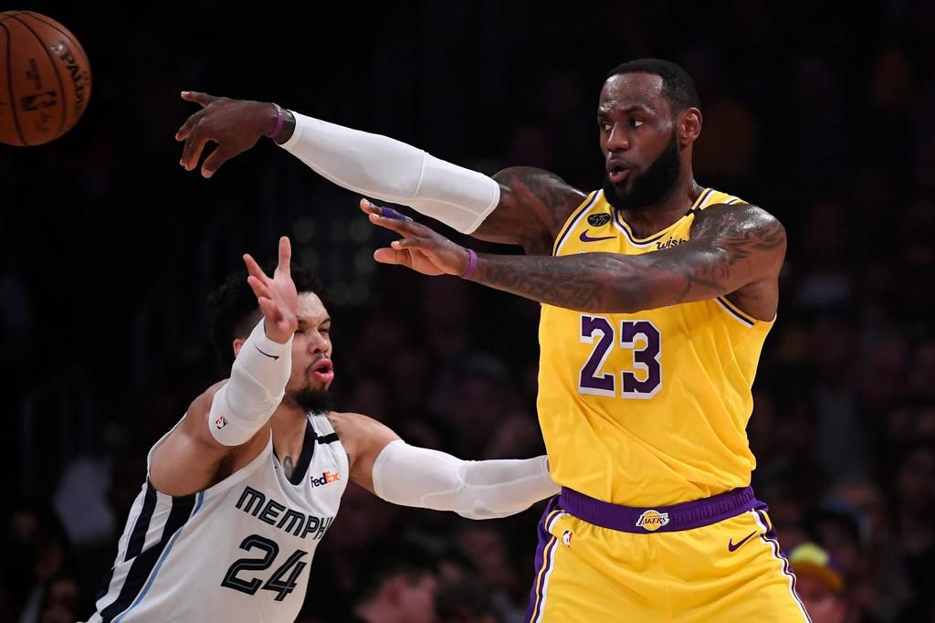 Los Angeles Lakers forward LeBron James, right, passes while under pressure from Memphis Grizzlies guard Dillon Brooks during the first half of an NBA basketball game Friday, Feb. 21, 2020, in Los Angeles. (AP Photo/Mark J. Terrill)