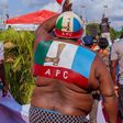 An APC party supporter waves the party's flag at an election campaign rally in Edo State [Twitter/@PastorIzeIyamu]