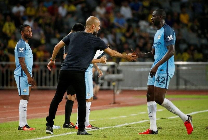 Manchester City manager Pep Guardiola with Yaya Toure as he is substituted as Raheem Sterling (L) prepares to come on