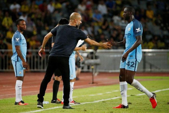 Manchester City manager Pep Guardiola with Yaya Toure as he is substituted as Raheem Sterling (L) prepares to come on